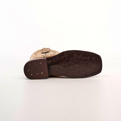 The image highlights the Palles Aztec Stitch Fawn cowboy boot, featuring Aztec-inspired stitching and an ornate design on its dark brown genuine leather sole. The heel and sole are prominently displayed against a white background.