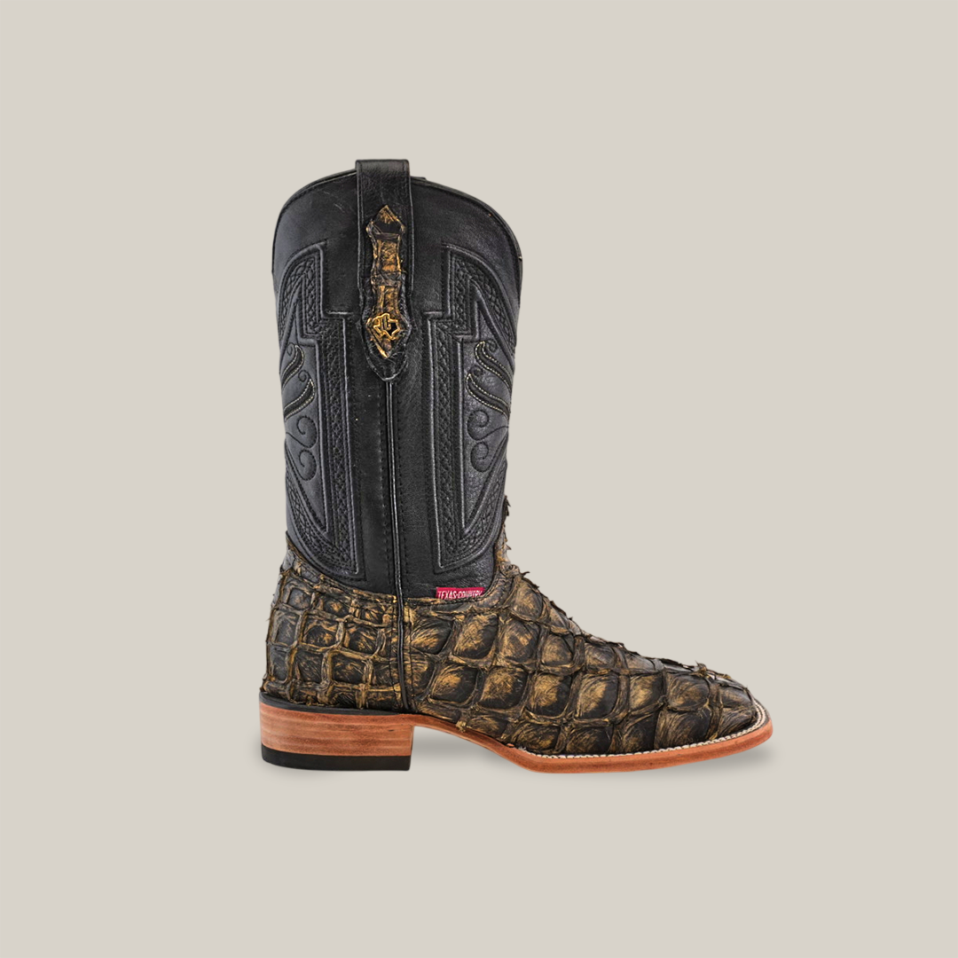 Side view of the Exotic Piraruco Fish - Rustic Antique showcasing a black detailed leather upper and brown textured lower with an animal skin design. This square toe boot features a light brown wooden heel and side label.