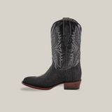 The Exotic Stingray - Black - Round Toe cowboy boot is made from stingray leather and features intricate shaft embroidery with a textured lower part, set off by a brown heel and sole against a plain beige background.