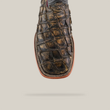 The Exotic Piraruco Fish - Rustic Antique - Square Toe boot features a textured brown, crocodile leather finish with detailed stitching and a visible shadow; it stands isolated against a plain light background, reminiscent of vintage style.