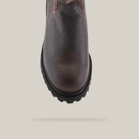 Close-up top view of the Brown Roper - Tractor Sole - Composite Toe boot, crafted from premium cowhide leather. It highlights its textured surface and rugged black tractor sole against a plain white background, displaying artisanal quality.