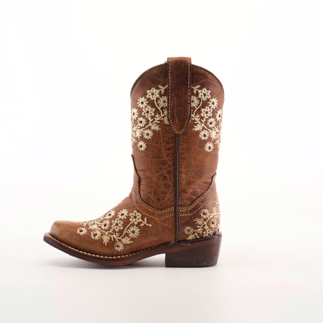 A single Abril Studs Orix Snip Toe cowboy boot in brown, featuring intricate white floral embroidery on the shaft and foot, showcased against a white background. This snip toe boot has a wooden heel and includes pull tabs for easy wear.