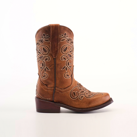 The Carola Tabaco - Snip Toe boots feature a brown design crafted from premium cowhide leather with intricate white embroidery on the shaft and toe, complemented by a low wooden heel, all set against a plain white background.