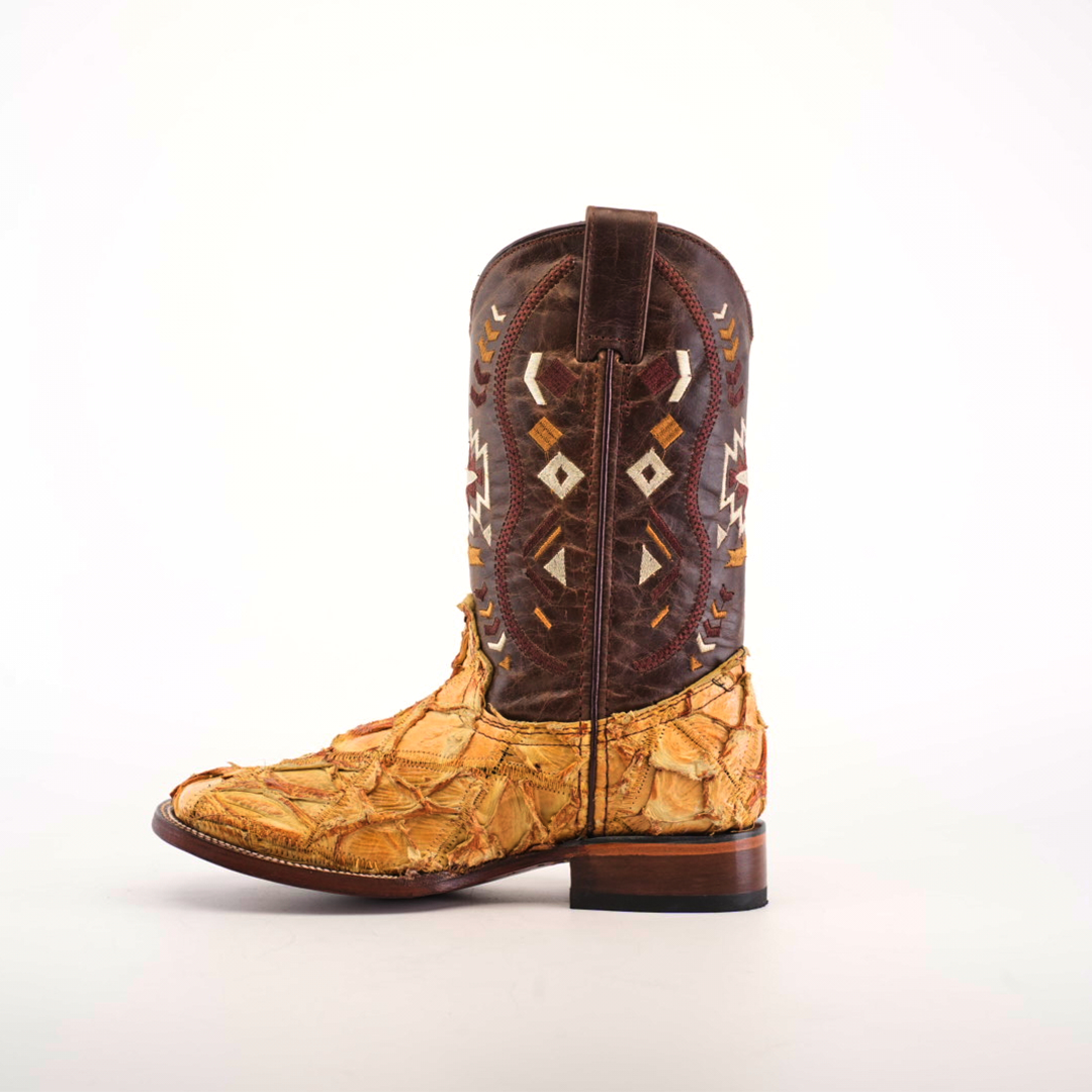 The Exotic Pirarucu Fish Patchwork Honey Square Toe cowboy boot highlights intricate geometric patterns on a dark brown shaft, complemented by a textured, multicolored beige and orange foot. With its wooden sole and pull tab on top, it features patchwork design for added charm.