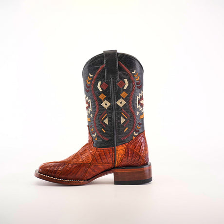 The Exotic American Alligator Patchwork Cogñac Square Toe is a single cowboy boot with Aztec-style designs and a colorful mix of brown, black, red, and orange. Its geometric patterns on the shaft pair perfectly with the smooth toe and wooden heel for a unique look.