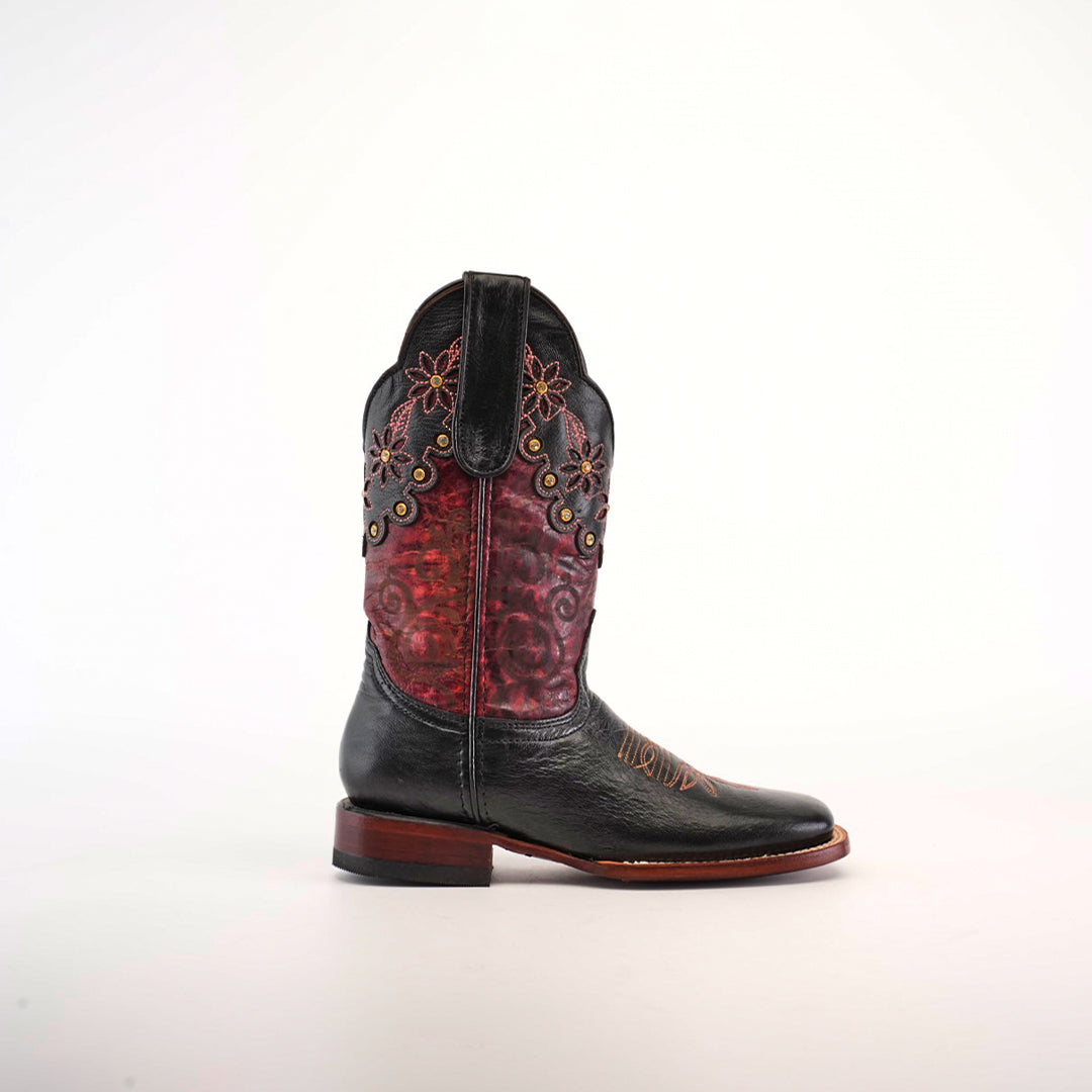 The Grecas Black - Short Shaft - Square Toe boot stands upright, exhibiting its exquisite craftsmanship with a black leather foot, red embossed upper with floral embroidery, brown stitching, and a wooden heel set against a plain white background.