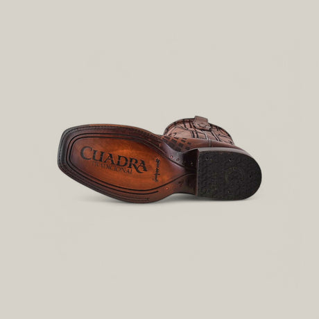 Bottom view of the Over Honey Laser & Embroidery & Woven - Square Toe - CU500, a brown leather cowboy boot with intricate stitching and laser detailing. The sole bears the embossed text CUADRA TRADICIONAL against a plain, neutral background.