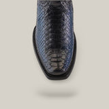 A top view of a single leather shoe, Lisboa Blue Python Laser & Woven - CU736, showcases a shiny python-like texture and Cuadra craftsmanship on a plain beige background. The shoe features a narrow square toe and intricate detailing.