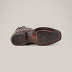 The image displays the sole of the Over Brown Python Laser & Embroidery - Narrow Square Toe - CU401 cowboy boot, made from python leather and showcasing detailed laser engravings with a textured pattern. The worn sole indicates use, and the boot lies horizontally on a plain, light background.
