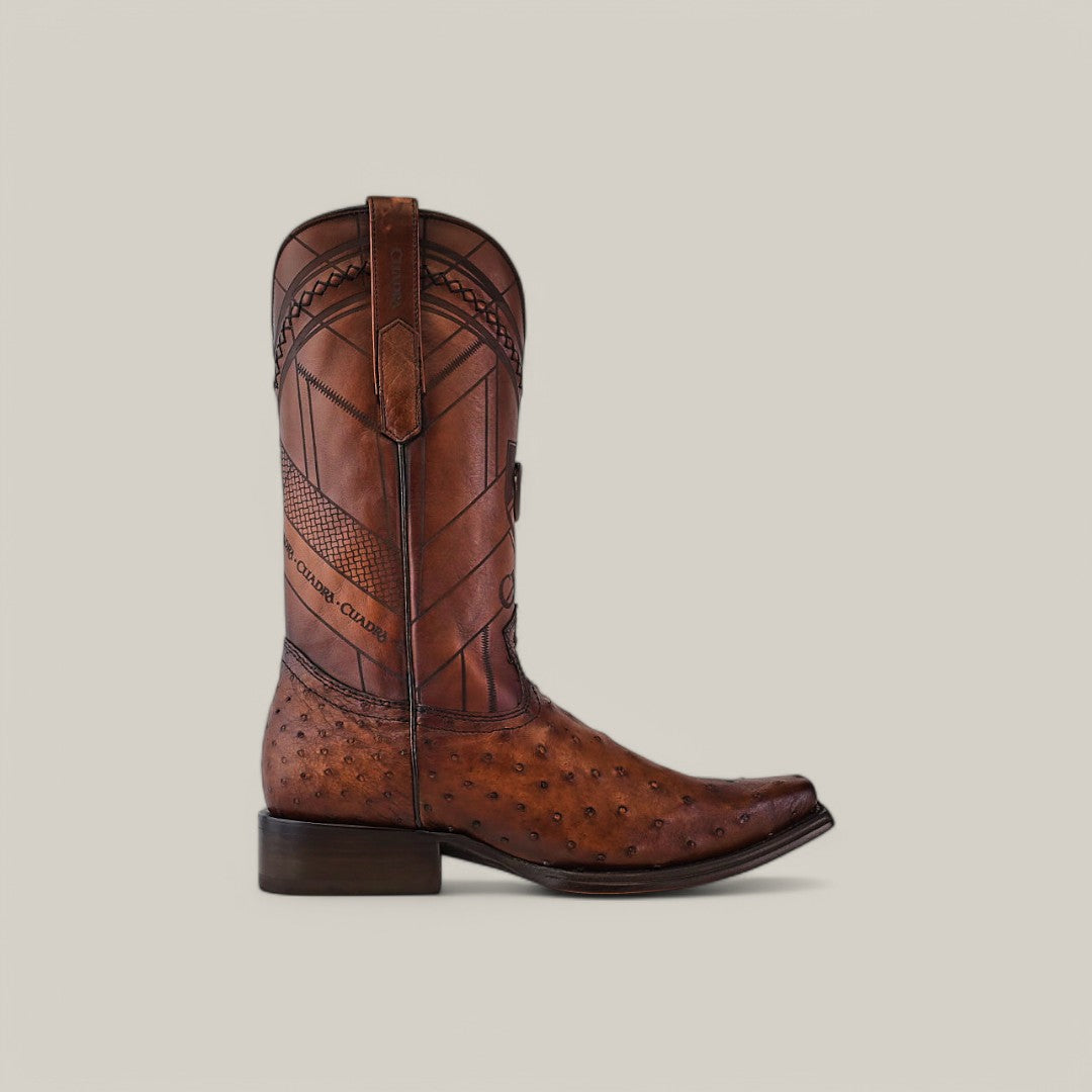 The Arauco Chocolate Ostrich Laser & Woven - CU597 cowboy boot showcases exotic leather with ostrich-patterned texture, decorative stitching, laser-engraved detailing, pull tabs, a short heel, and a narrow square toe. Displayed against a light background.