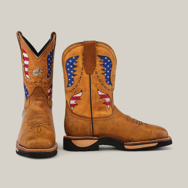 The Taurus Honey Soft Toe - E6189 boots are tan cowboy boots adorned with an American flag-themed embroidery of red, white, and blue stars and stripes. Built for durability, they feature decorative stitching and a side pull-tab for easy wear.