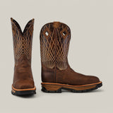 The Amazonas Tanger Composite Toe - E6257 are brown leather cowboy boots with intricate white stitching patterns and square toes, offering Texas Country charm. The left boot is angled to show the side design, while the right boot is forward-facing. These durable, waterproof boots have black soles and a slight heel.