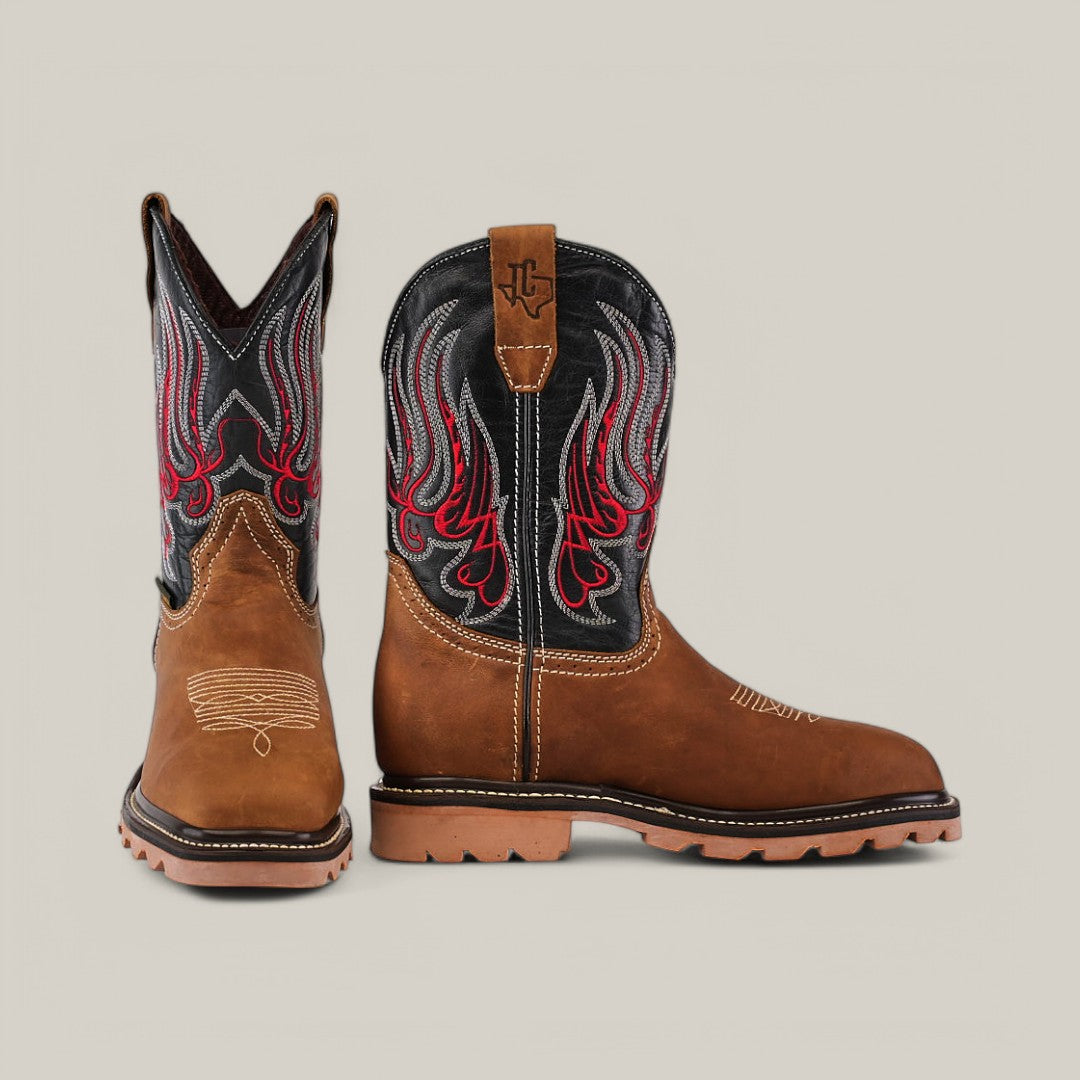 The Crazy Tang Composite Toe - E6015 cowboy boots exhibit Texas Country durability with their brown leather, black and red flame embroidery on the shafts, rugged sole, and detailed toe stitching. One boot faces forward and the other is turned to the side against a neutral background.