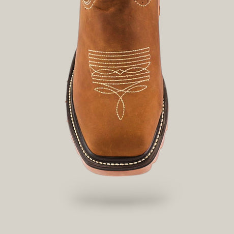 The Crazy Tang Soft Toe - E6015 cowboy boot features intricate white stitching on the toe, a layered light brown and black sole and heel, creating a distinct look. Viewed from the front, these durable boots stand out against a solid light gray background.