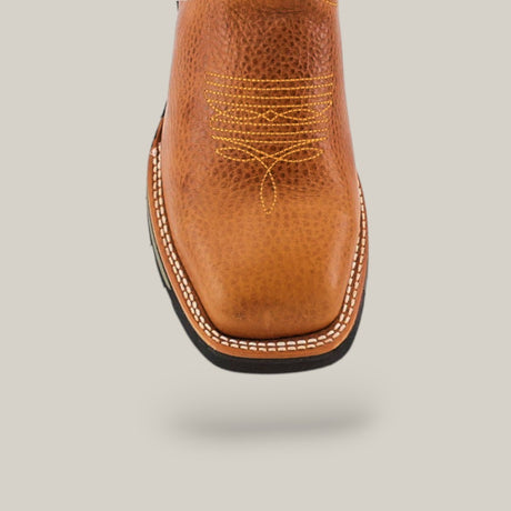 Close-up of a Rino Honey Composite Toe - E6077 boot in brown leather, with intricate yellow toe stitching and white edge stitching. Known for durability and comfort, its beautifully showcased against a plain light gray background.