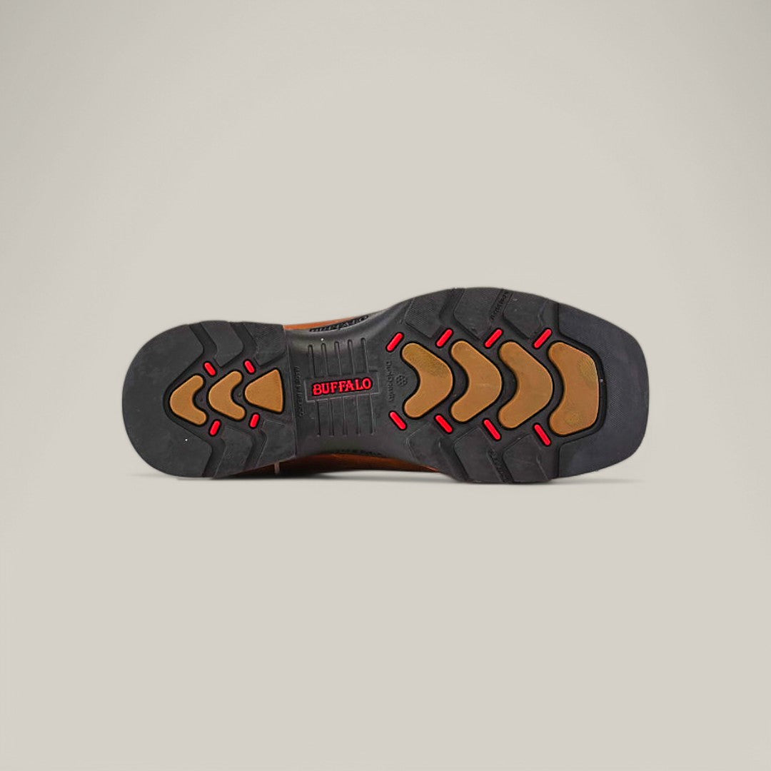 The image showcases the sole of the Texas Honey Composite Toe - E6082, featuring durable black and brown rubber with red accents and BUFFALO stamped on it. A geometric pattern enhances traction, while a light beige background highlights its rugged design.