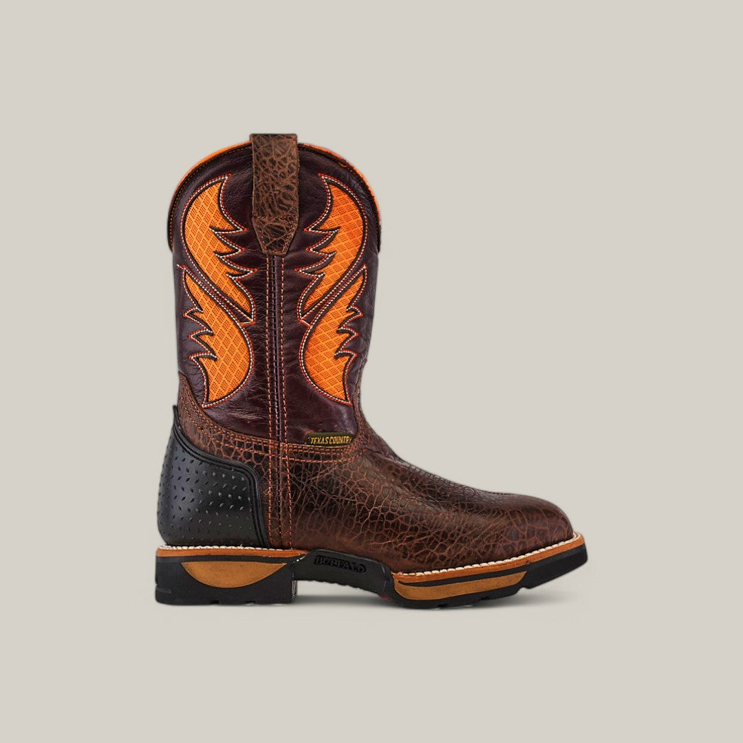 The Jurasic Brown Composite Toe - E6089 boot has a dark brown textured leather upper with orange flame-like stitching, a black textured heel, a sturdy treaded sole, and a round toe. Orange accents adorn the shaft of this durable Texas country work boot.