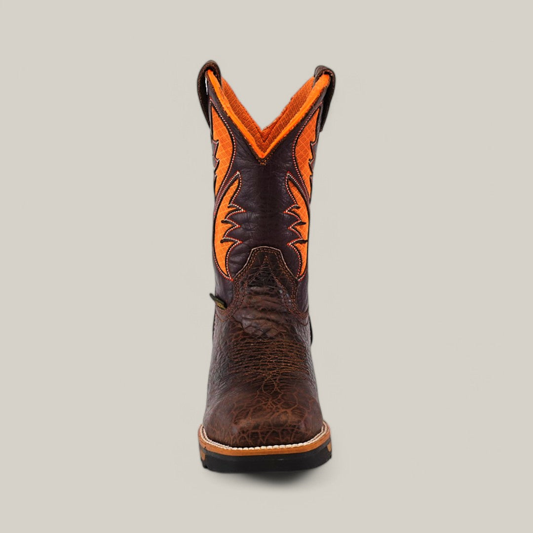 The Jurasic Brown Composite Toe - E6089 boot features a brown textured leather foot and a vibrant orange and brown patterned shaft, set against a light gray backdrop. It embodies durability and style, perfect for the rugged demands of cowboy life.