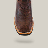 Close-up of the Jurasic Brown Soft Toe - E6089 cowboy boot with a textured surface and intricate patterns. It features a square toe and detailed edge stitching, known for its durability. The background is light gray.