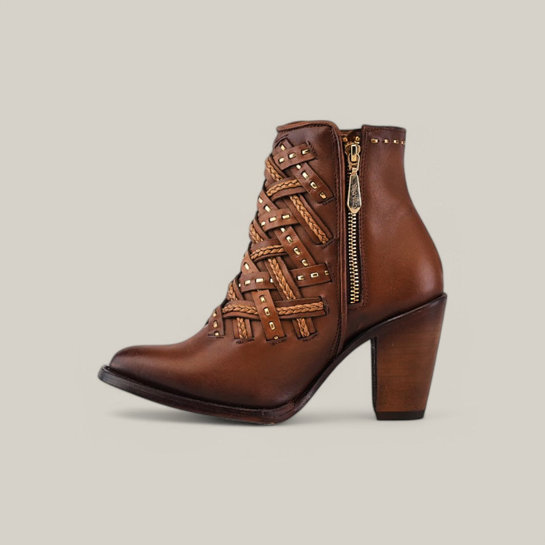 Introducing the Cuadra Toledo Chestnut Laser & Woven ankle boot in brown leather, featuring a round toe, high wooden heel, crisscrossing braided straps with gold studs, and a side zip closure. Set against a light beige background, it highlights its elegant design.