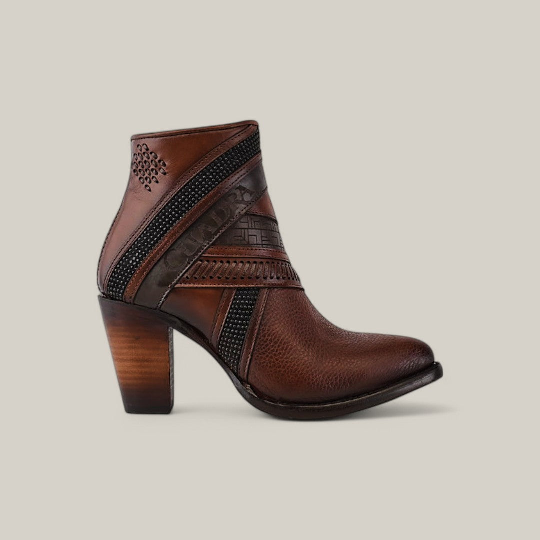 The Honey Laser & Woven - Round Toe - CU619 womens ankle boot showcases a brown leather design with decorative black trim and embossed patterns. Featuring a chunky wooden heel, it stands out stylishly against a plain light gray background.