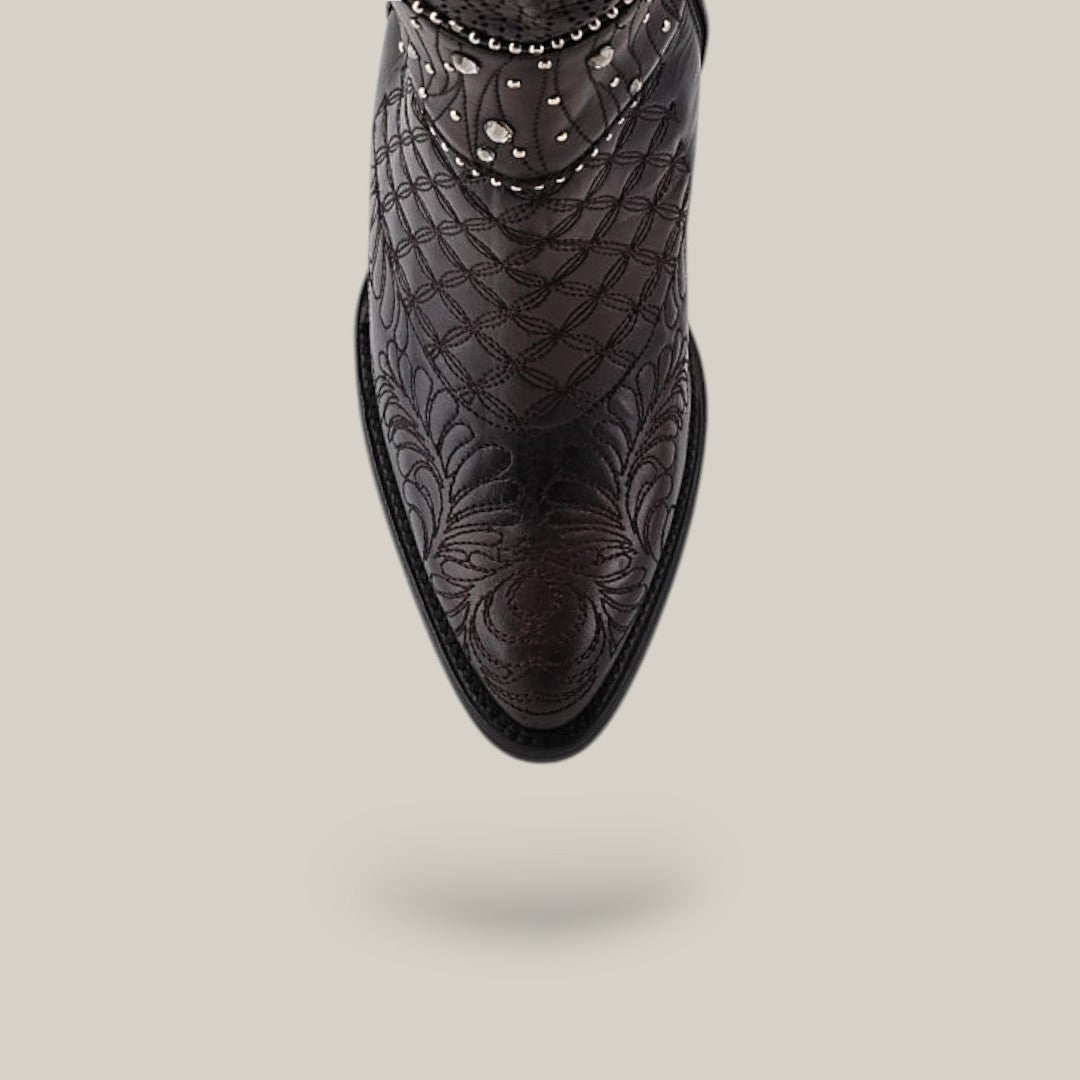 Close-up of a Black/Brown CU584 boot with intricate embroidery and decorative silver studs. The round-toe boot is suspended against a plain light gray background.