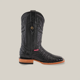 Discover Western sophistication with the Exotic Caiman Belly - Black - Square Toe cowboy boot. It boasts intricate shaft stitching, a Caiman Belly leather foot pattern, a wooden heel, and a small red tag on a light gray background—ideal for Cowboy Connoisseurs.