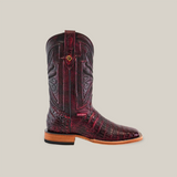 The Exotic Caiman Belly - Black Cherry features a dark red leather square-toe cowboy boot with intricate shaft patterns and an alligator pattern resembling caiman belly on the foot. It includes a brown stacked heel, pull strap, and a contrasting tan sole, ideal for any cowboy footwear collection.