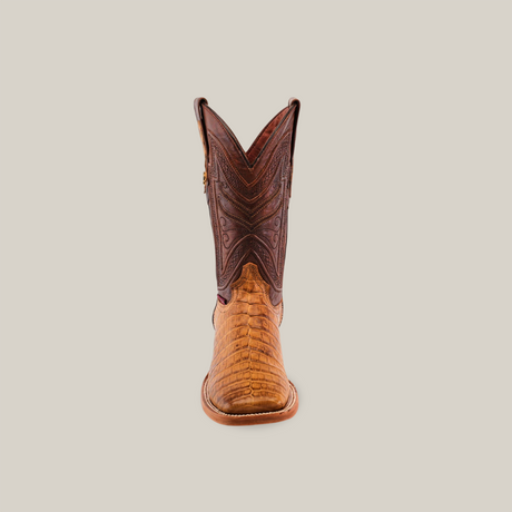 Front view of a single Exotic Caiman Horn Back cowboy boot in tan and brown leather, featuring intricate stitching on the upper and textured lower section, set against a plain beige background. Made from genuine leather with a square toe design.