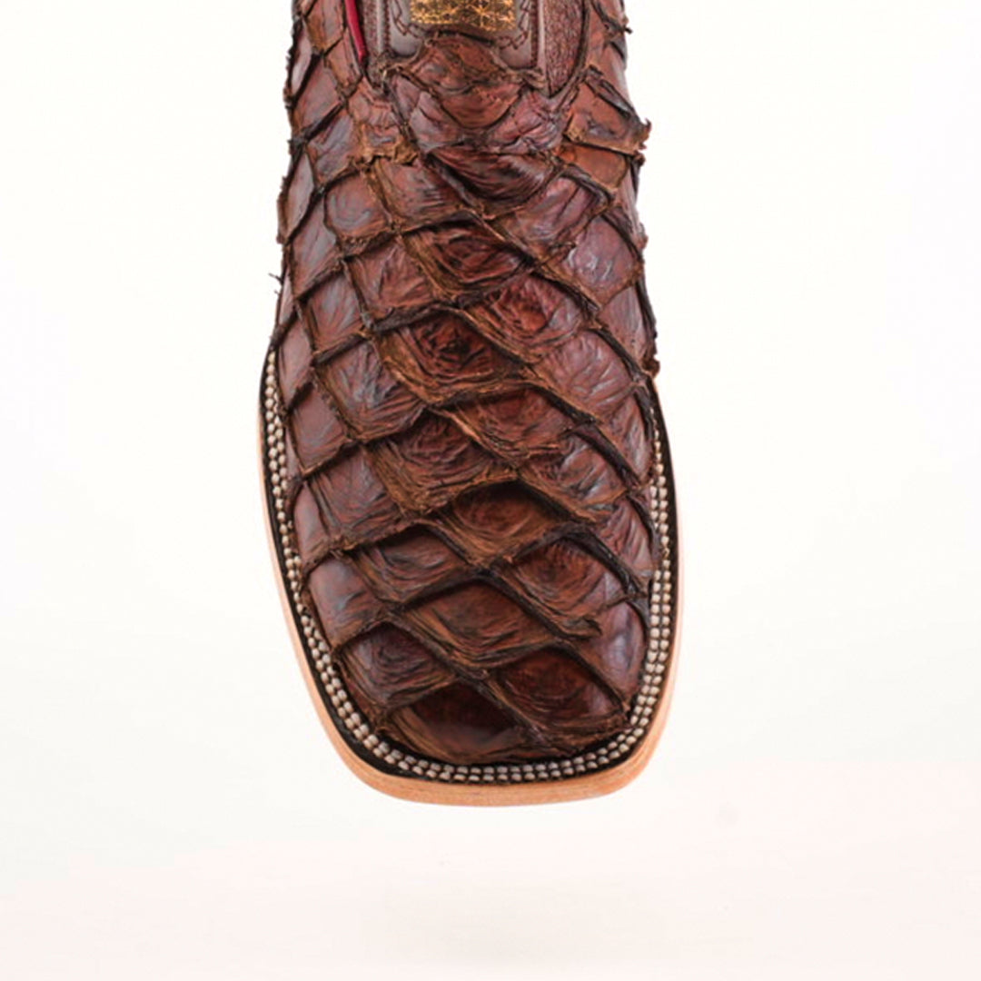 Close-up of the Exotic Piraruco Fish - Matte Brown - Square Toe boot. Crafted from exotic leather with a textured reptile-skin-like design, it features detailed stitching around the sole on a light, neutral background.