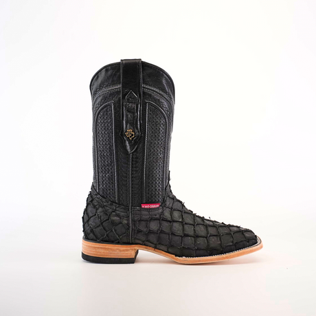 An Exotic Piraruco Fish boot in matte black stands upright against a white background, featuring a textured, scaled surface, square toe, wooden sole, intricate stitching, decorative pull tab, and emblem in authentic leather.