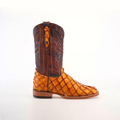 The Exotic Piraruco Fish - Brandy - Square Toe cowboy boot showcases a unique two-tone design with a dark brown, intricately stitched upper and vibrant, textured orange lower section mimicking Piraruco fish scales. It features authentic fish leather, a low heel, pull straps, and a leather sole.