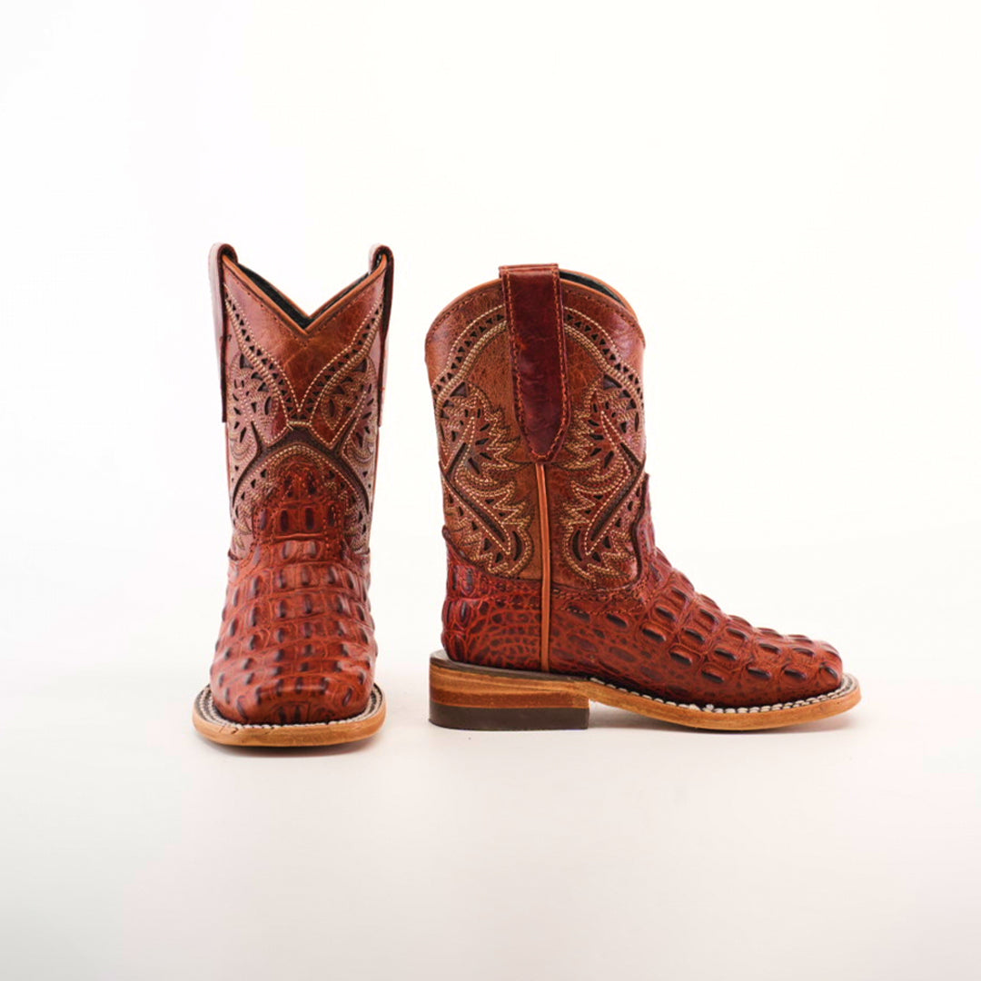 The Caiman Hornback Print Cogñac Square Toe boots showcase intricate patterns with a crocodile-like texture on the foot and detailed stitching on the shaft. Handcrafted from premium leather, they feature a square toe design and rest elegantly against a plain white background.