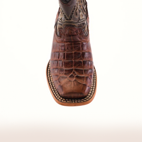 Close-up of a handcrafted Caiman Belly Print Chocolate Square Toe boot with intricate stitching and decorative patterns on premium leather, complemented by a light brown sole, exuding timeless elegance.