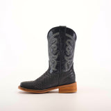 The Python Print Matte Black Square Toe boot is crafted from cowhide leather, featuring a textured surface and intricate white stitching on the upper part, resting on a wooden heel, all set against a plain white background.