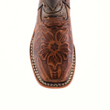 The image showcases a top view of the Handtooled Leave Brown Square Toe boot, crafted from premium cowhide leather. It features an intricate floral carving on the toe and a white and brown stitched edge, enhancing its handmade charm.