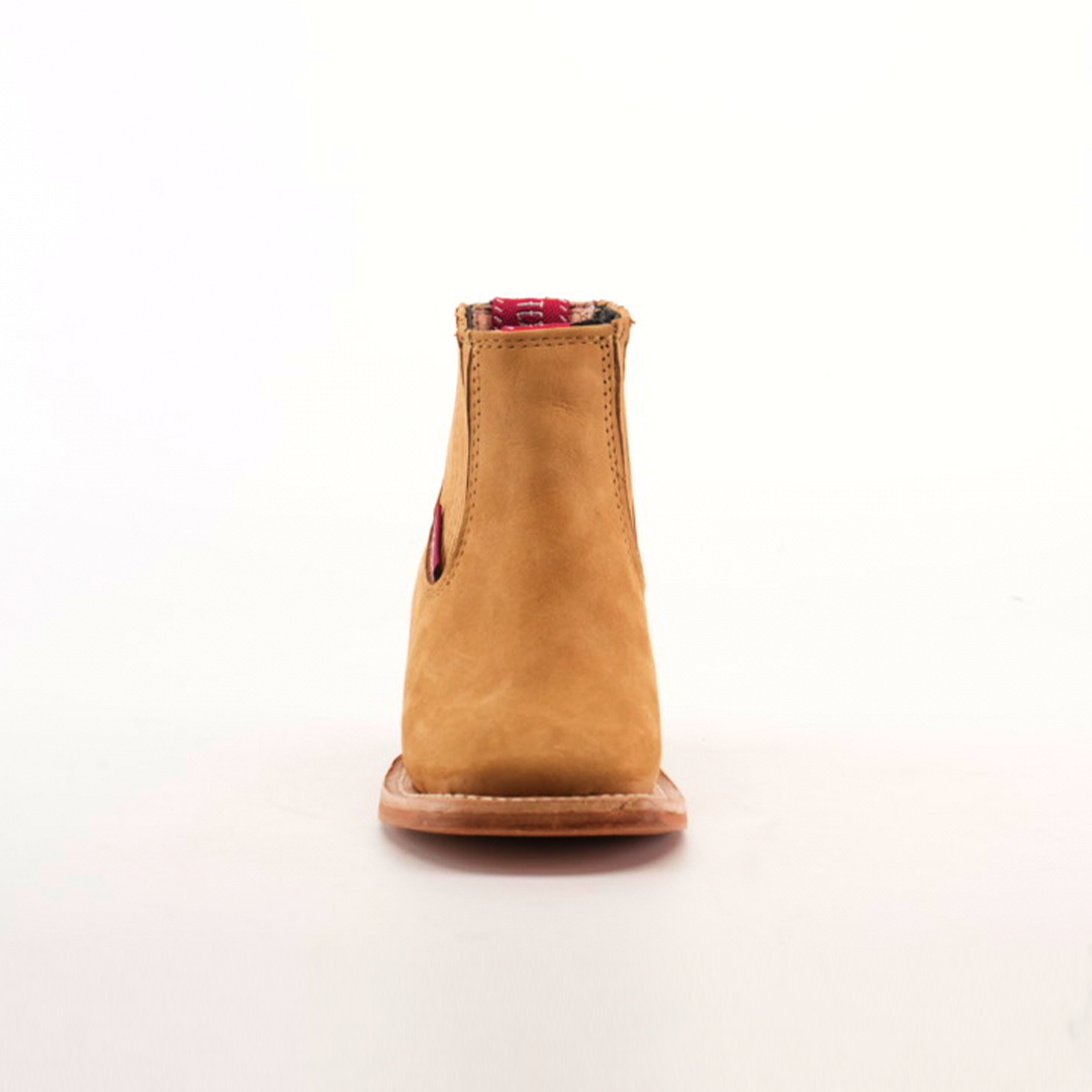 The Prime Suede Honey Square Toe is displayed from the front against a plain white background. This tan suede ankle boot with a red elastic side gusset features a square toe and sturdy sole, crafted from genuine leather for lasting quality and style.