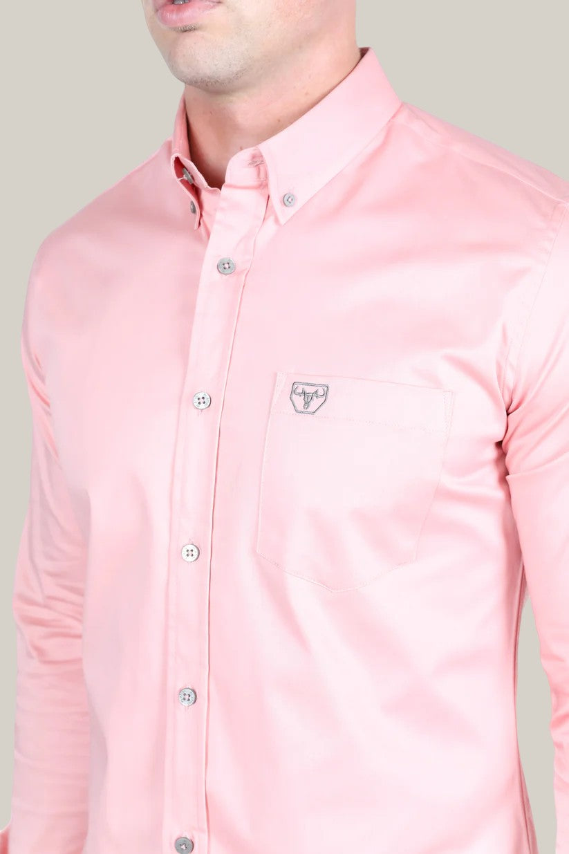 A person is wearing the Men’s Single Pocket Logo Modern Fit Stretch Dress Shirt in pink (CTL9826), featuring a chest pocket, embroidered logo, pointed collar, and white buttons. The background is plain light gray.