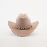 The 6X Sinaloa Belly is a light brown cowboy hat made from sheeps wool, featuring a wide brim and a decorative band with metal accents. It embodies Western heritage against a plain white background.