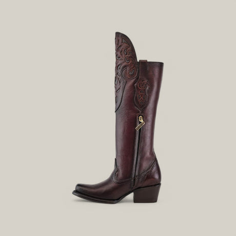 The California Tall Shaft Brown - Round Toe boot, from the Platinum Collection, features intricate floral stitching on its shaft and a decorative metal zipper. It has a square toe, low stacked heel, and is set against a plain beige background.