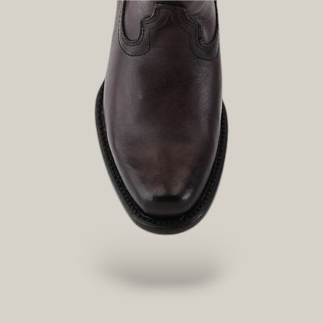 Close-up of a single brown leather shoe from the California Tall Shaft collection viewed from above on a plain gray background. The shoe showcases subtle stitching details and a rounded toe.