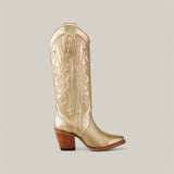 The stunning Linda Tall Shaft Gold - J Toe boot from the Platinum Collection features intricate gold stitching, a tall shaft, uniquely rounded pointed toe, mid-height wooden heel, and pull straps for easy wear.