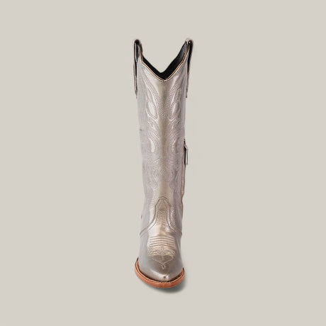 The Linda Tall Shaft Mercury - J Toe boot from the Platinum Collection showcases a metallic silver design with intricate embroidery on the shaft, featuring a slightly pointed toe and stacked heel against a plain beige background for a striking look.