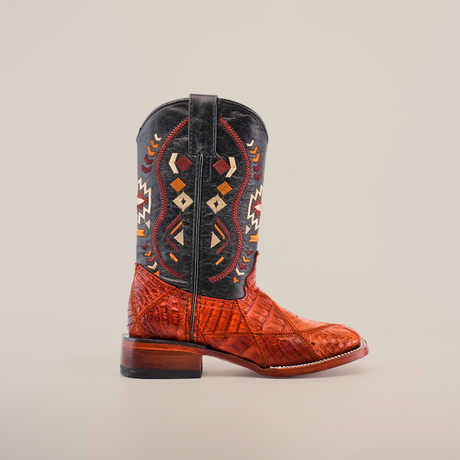 The Exotic American Alligator Patchwork Cogñac Square Toe boot features a black upper with colorful, geometric embroidery resembling a patchwork design. The lower part is made of textured brown alligator leather with a slight heel, set against a plain white background.