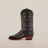 Displayed against a white background, the Mayan Flower Crystals Black cowboy boot features intricate floral embroidery on its black leather. This handcrafted piece has a narrow square toe and wooden heel, showcasing exquisite craftsmanship.