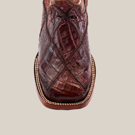 Close-up of an Exotic American Alligator Patchwork Brown Square Toe cowboy boot against a white background, showcasing the genuine alligator skin with intricate stitched patterns and rounded edges.