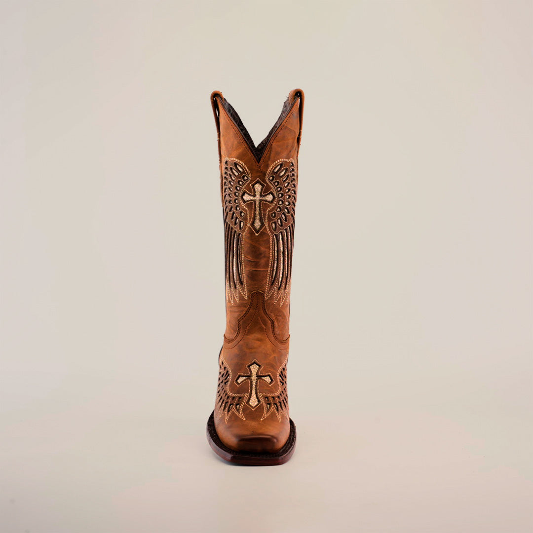 The Texas Cross Glitterbomb Camel boot, with chic glitter details and intricate cross and wing patterns, is showcased against a white background. Its a single brown cowboy boot made of premium leather crafted with care.