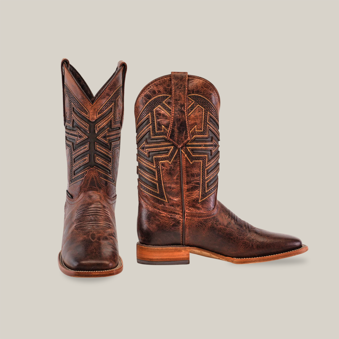 The Rustic Brown - Square Toe boots are made from cowhide leather with detailed black and beige stitching. One boot stands upright, revealing its side design, while the other is angled to show the front pattern. Both rest on a plain white background.