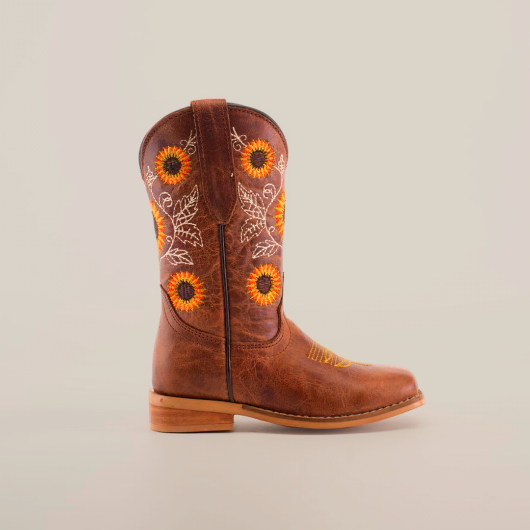 The Sunflowers Tabaco - Square Toe boot highlights top-notch craftsmanship with sunflower and leaf embroidery on premium leather. This single brown boot, displayed on a plain white background, features a durable wooden heel.