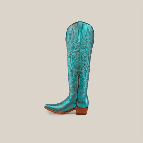 Introducing the Brittany Rustic Ceramic Tall Shaft Snip Toe Boot: a turquoise cowboy boot with leaf patterns, pointed toe, low brown wooden heel, genuine leather sole, side zipper closure, and decorative stitching.